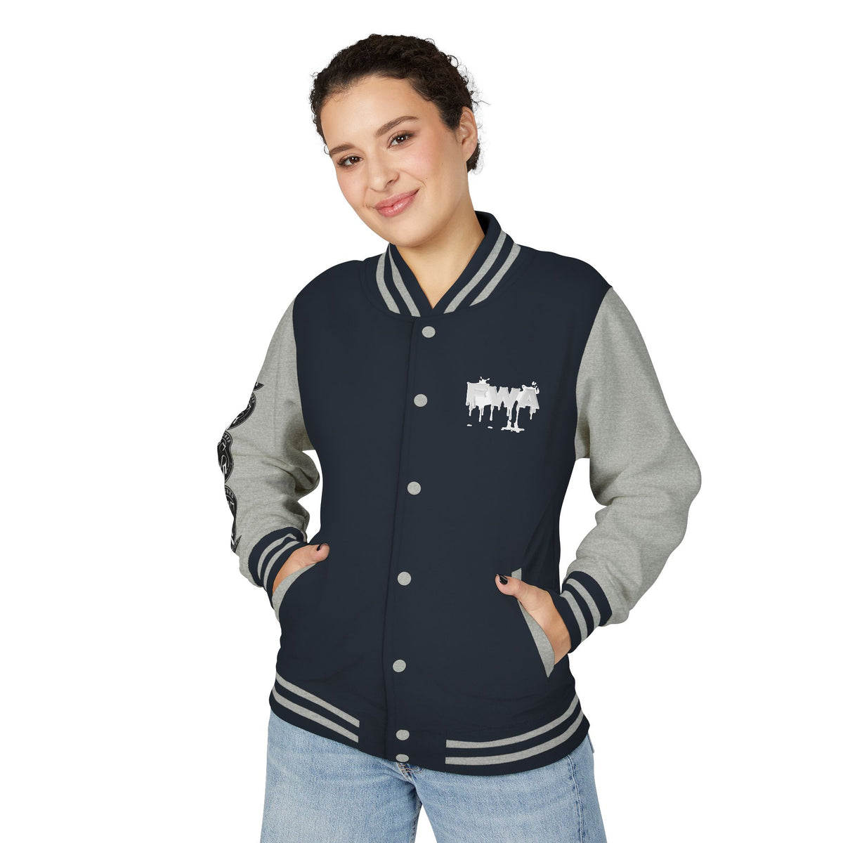 Front view of a woman wearing a Faith In Motion Varsity Jacket in navy with gray sleeves and white paint-drip text.