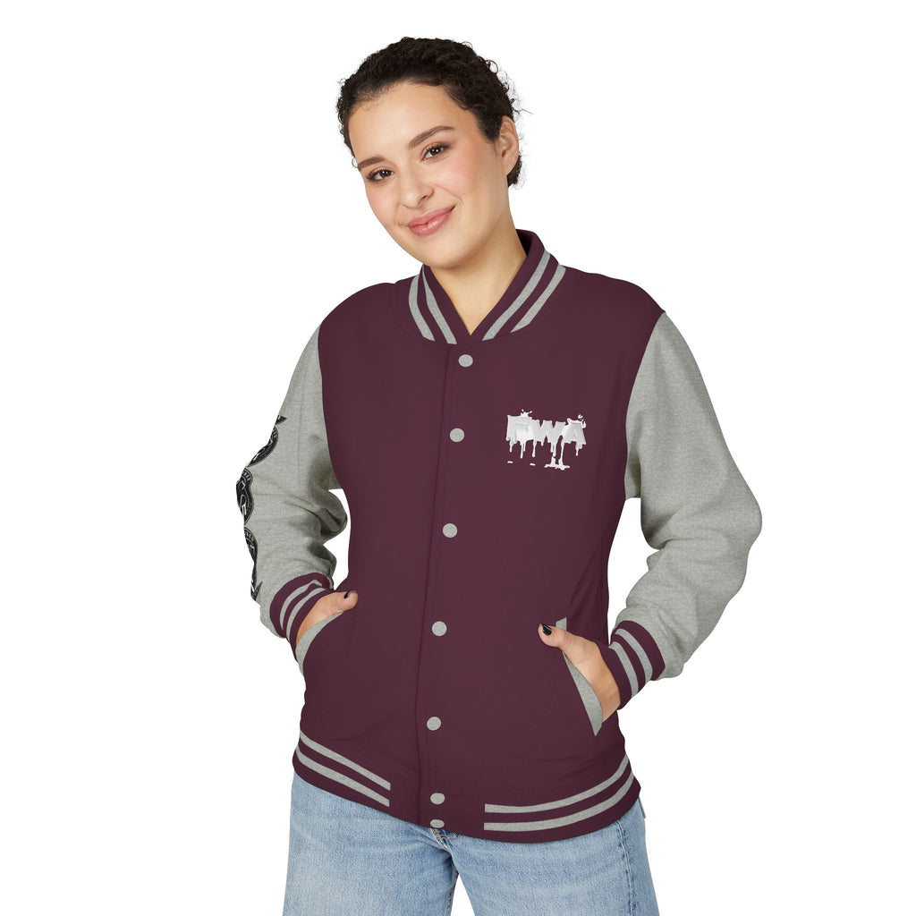 Front view of a woman wearing a Faith In Motion Varsity Jacket in maroon with gray sleeves and a white paint-drip graphic.