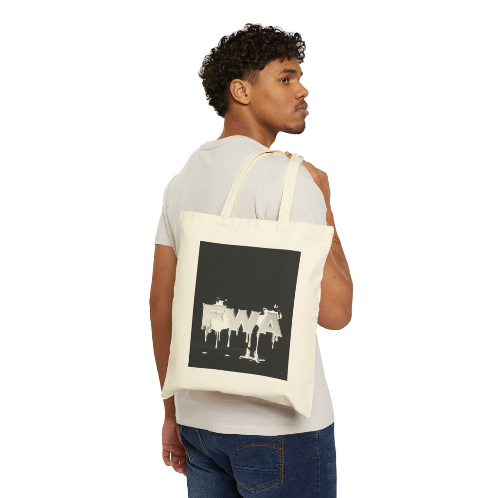 Man carrying a Drip Paint 'EWA' Canvas Tote Bag over his right shoulder, showing the black and white graphic.