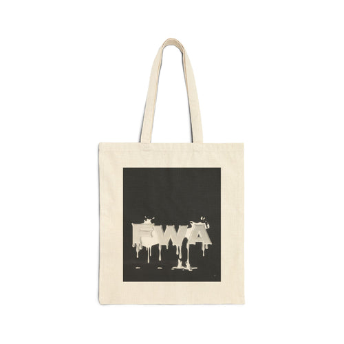 Front view of a natural canvas tote bag with a black square graphic featuring "EWA" in dripping white paint.